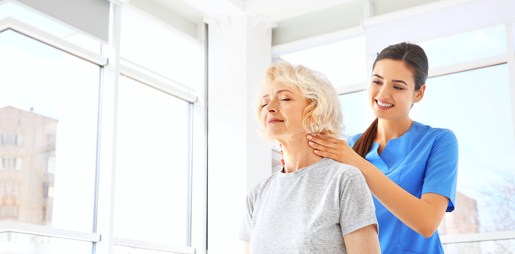 caregiver massaging a senior woman